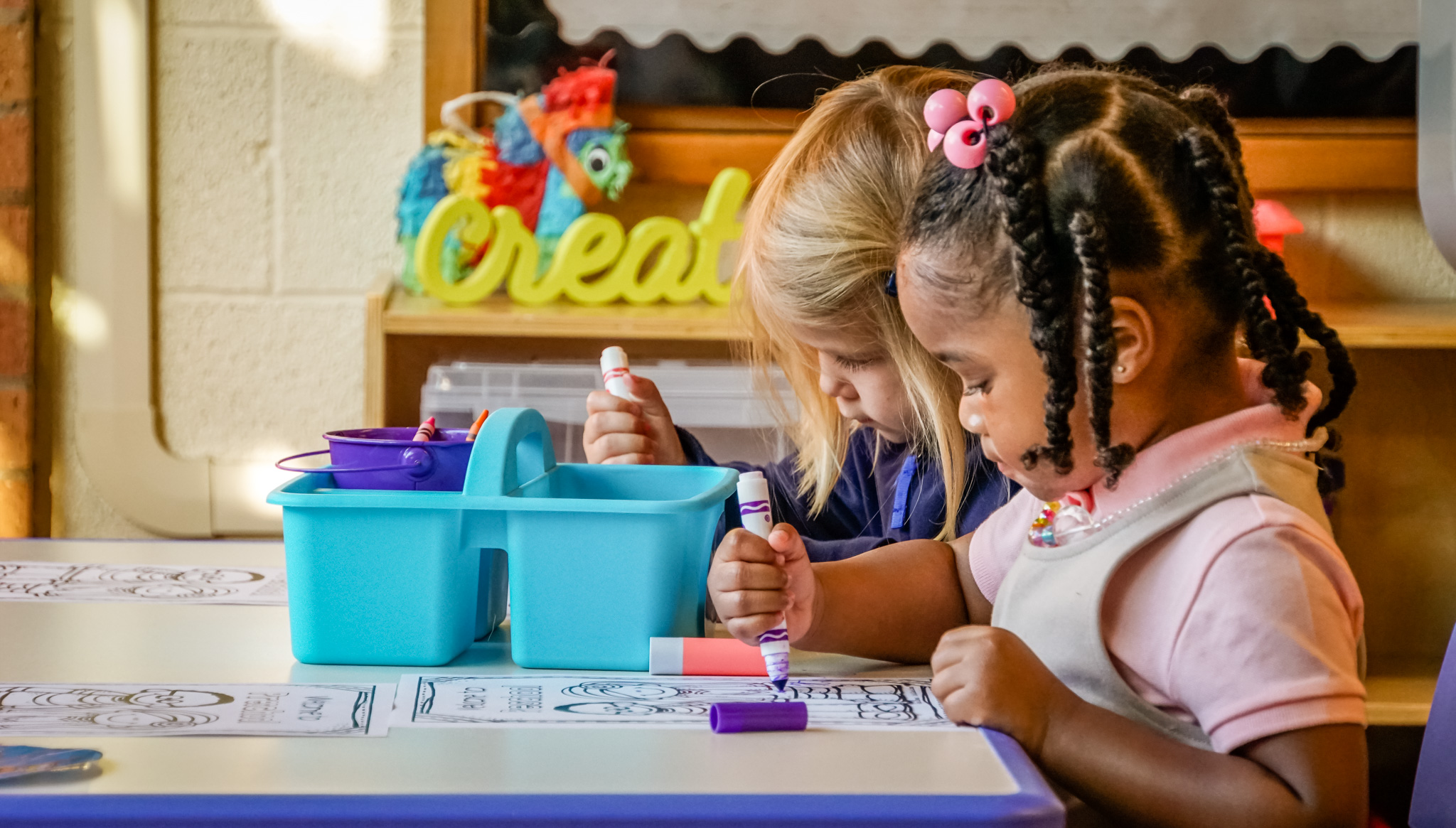 preschoolers sitting at round tables